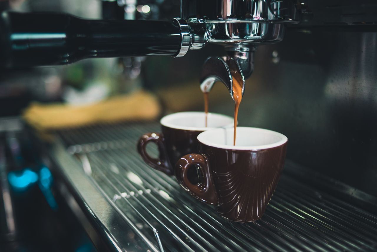 Home Close-up of a professional espresso machine brewing coffee into cups.