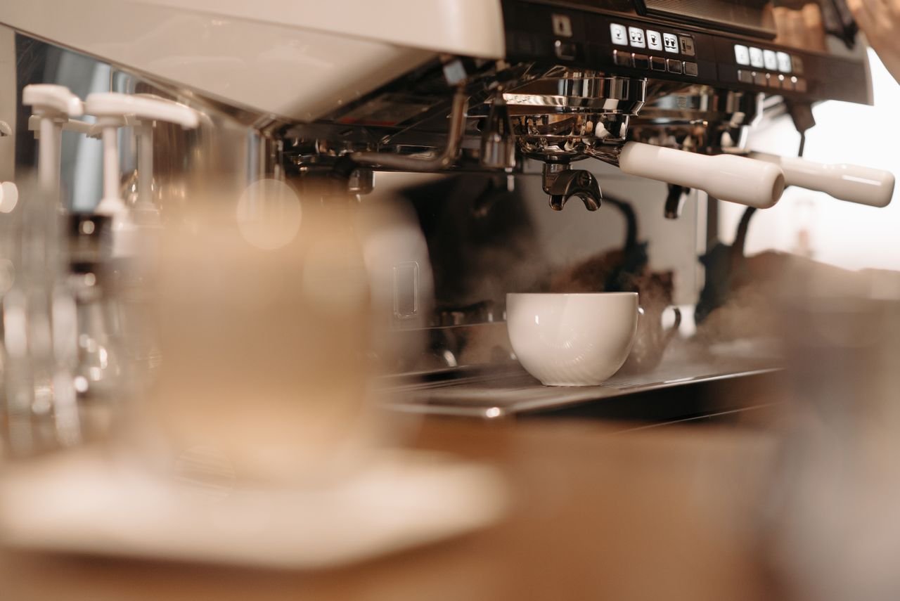 The Art of Drawing Readers In: Your attractive post title goes here Steam rises as an espresso machine brews a fresh cup of coffee indoors.